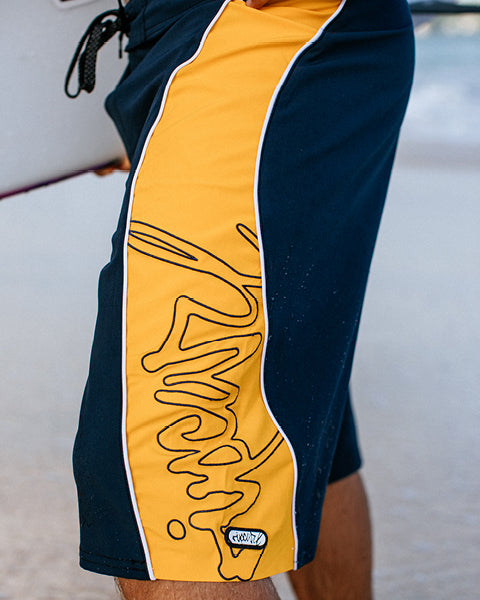 Navy and yellow shorts with a logo on a blurred background