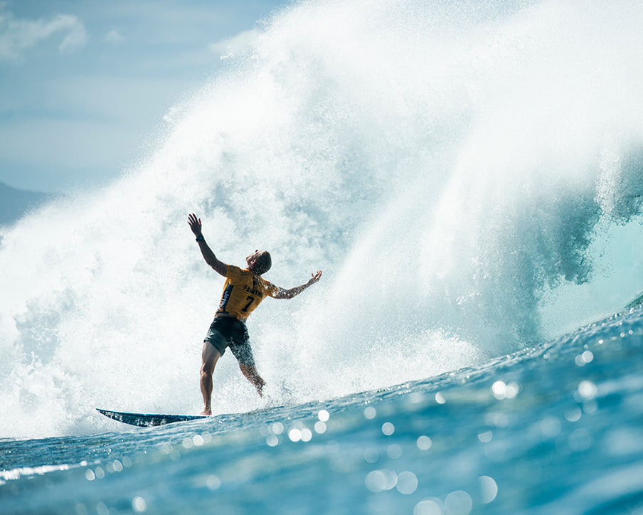 Surfer riding a large wave with arms outstretched