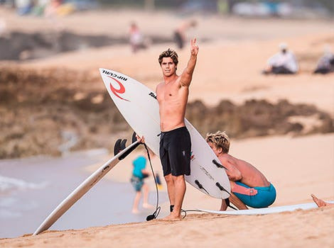 man standing on the beach with a surfboard