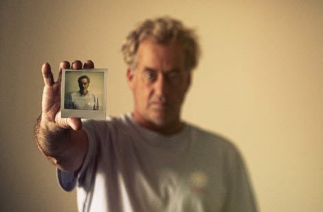 The surfer Tom Curren holding a photo