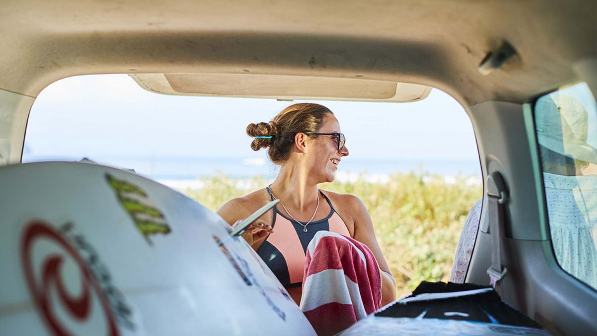 Tyler Wright grabbing a surfboard out of the car