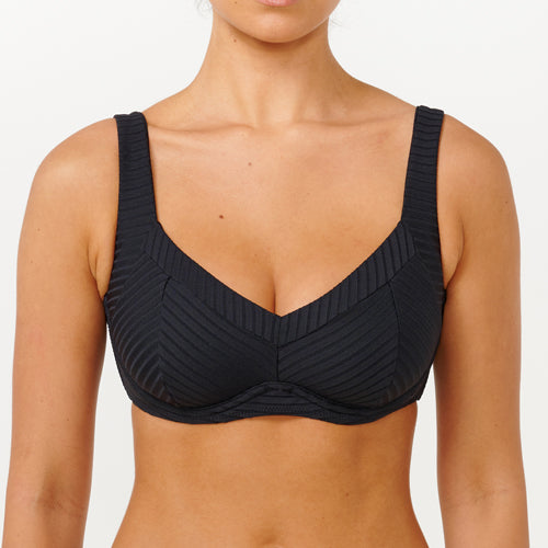 Black sports bra worn by a person on a white background
