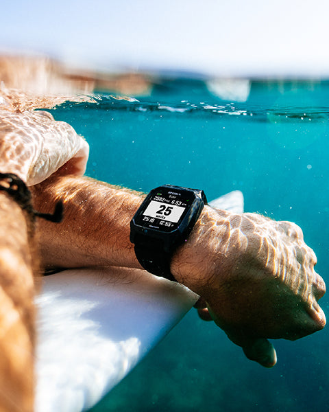 Person underwater wearing a smartwatch with a digital display