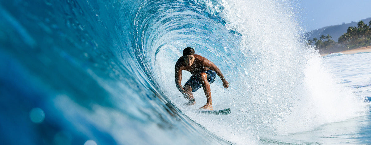 Person surfing a wave in a blue ocean