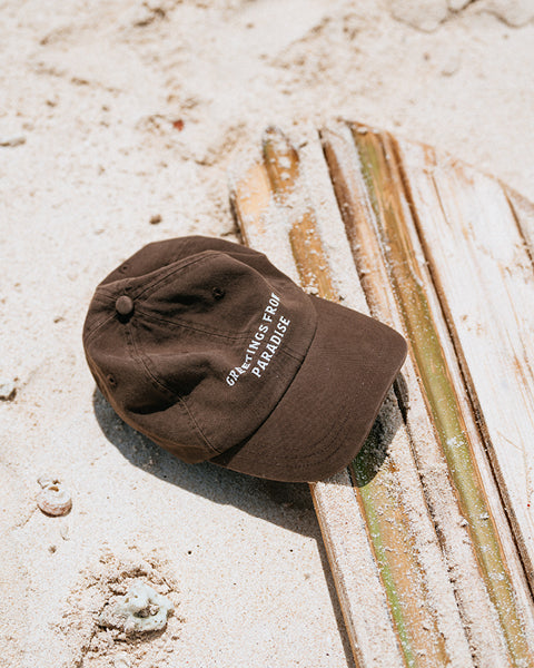 Brown cap with text on a sandy surface